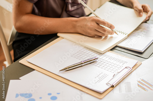 close up of a person writing on a paper