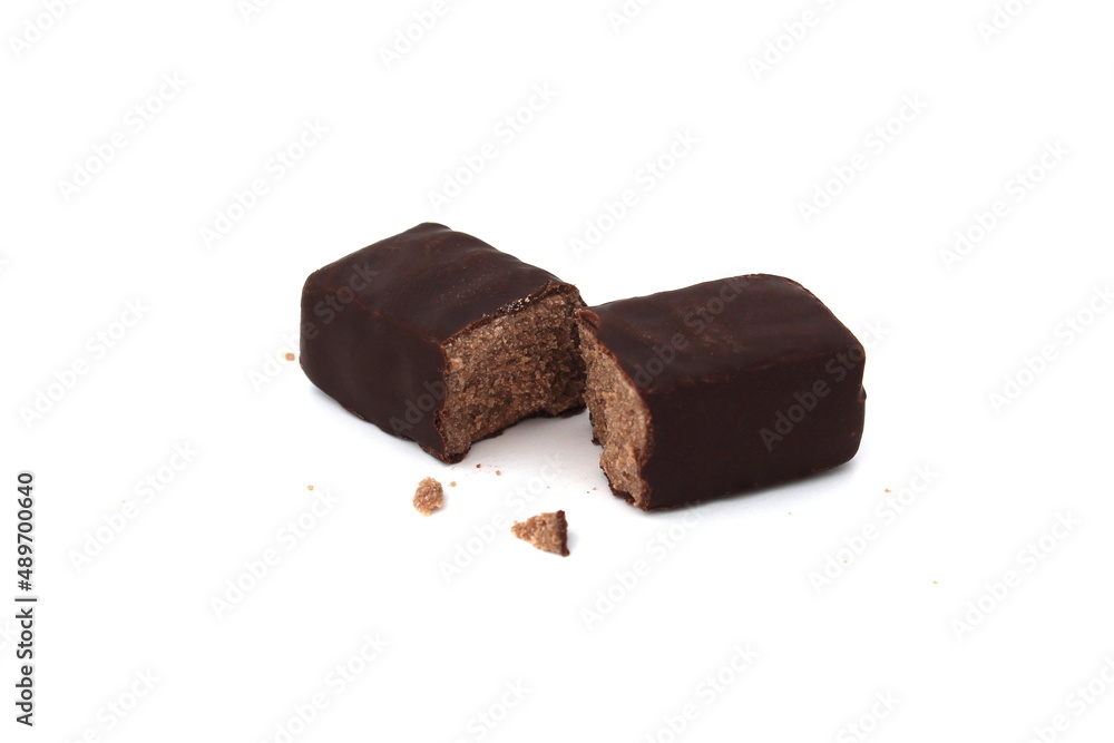 Chocolate candy broken in half lies on a white background.