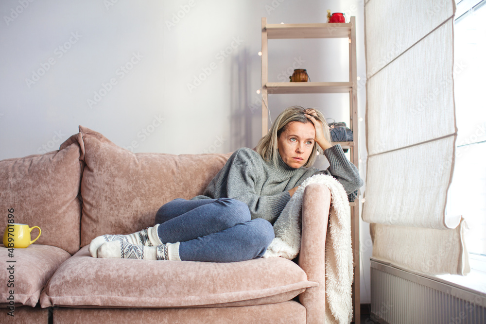Obraz premium Depressed lonely unhappy mental woman sitting alone on the sofa feel stress