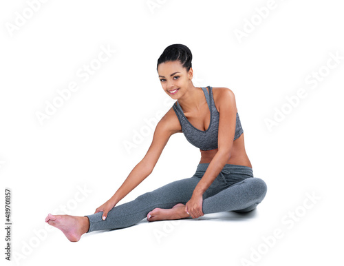 I stretch before every workout. Full length portrait of a female athlete stretching against a white background.