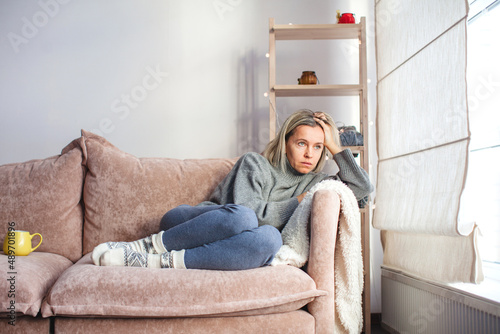 Depressed lonely unhappy mental woman sitting alone on the sofa feel stress photo