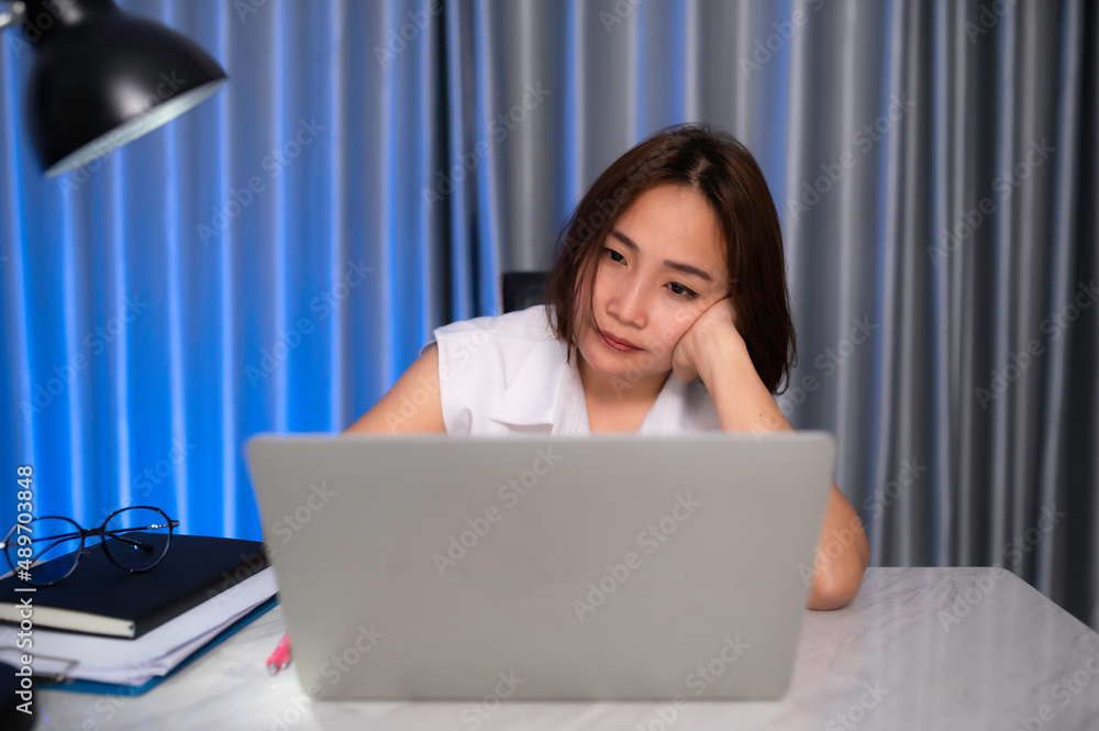 Fototapeta premium Beautiful asian woman working at home on the night,A lot of work from company,bring home work,Work from home concept,Tired from hard work