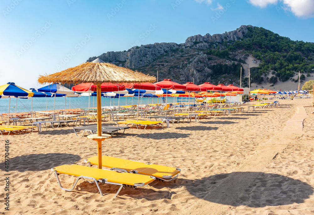 Sunbeds and umbrellas on Tsampika beach, Rhodes island, Greece