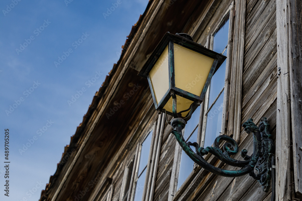 Street lamp with patterns on an old wooden house, retro style, in town, Bulgaria Street lamp with patterns on an old wooden house, retro style, in town, Bulgaria