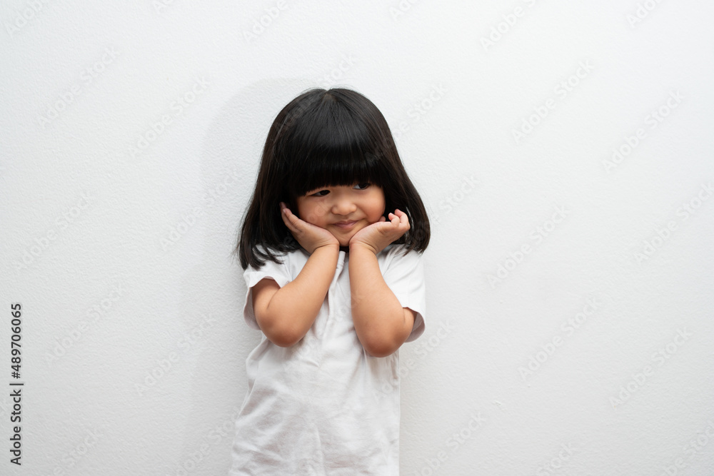Portrait of happy and funny Asian child girl on white background, a child looking at camera. Preschool kid dreaming fill with energy feeling healthy and good concept Portrait of happy and funny Asian child girl on white background, a child looking at camera. Preschool kid dreaming fill with energy feeling healthy and good concept