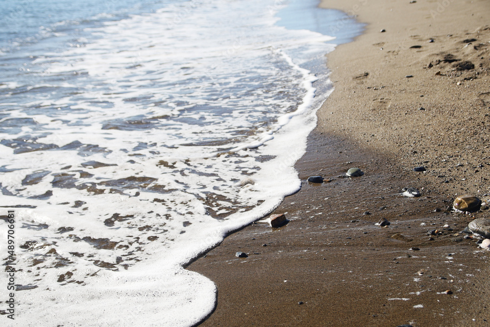 Sea water foam at sandy beach in Spain background Sea water foam at sandy beach in Spain background