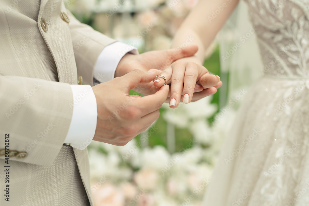 A married couple exchanges wedding rings at a wedding ceremony. The groom put the ring on the finger of his beautiful wife. A married couple exchanges wedding rings at a wedding ceremony. The groom put the ring on the finger of his beautiful wife.