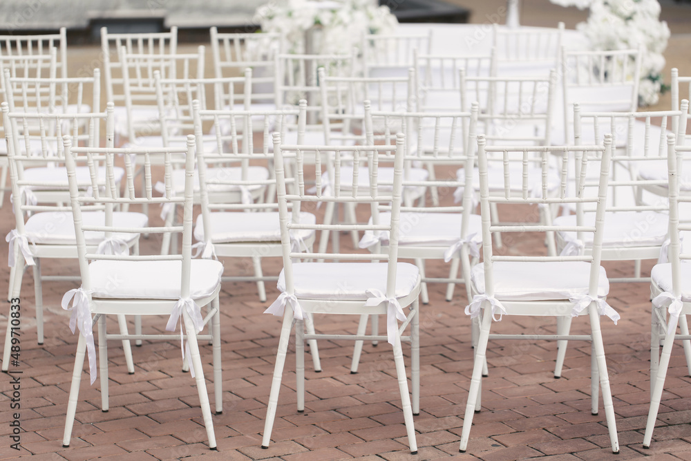 Outdoor area for wedding ceremonies with white chairs