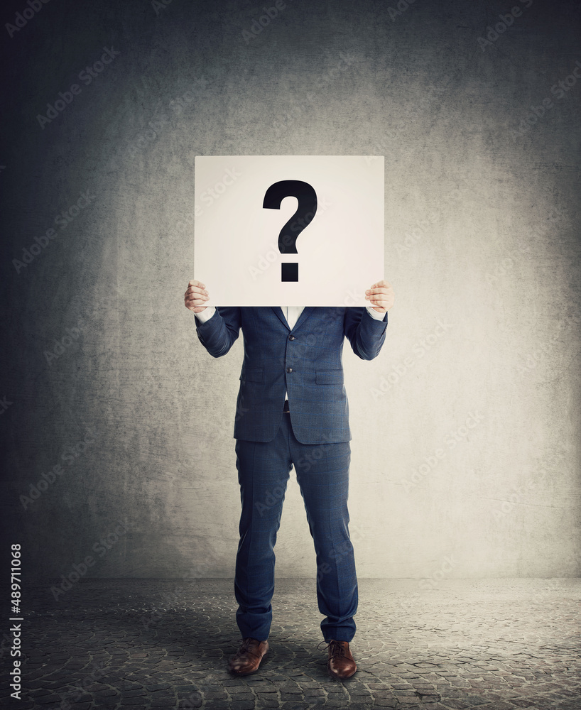 Anonymous Businessman Covering Head Using A Banner With Interrogation 
