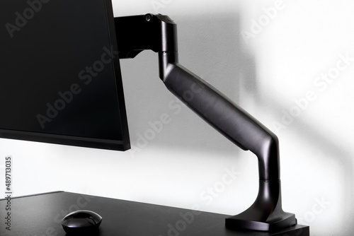 Canvas Print Modern matte computer monitor or TV set is mounted on a small table using a metal bracket - a gas lift