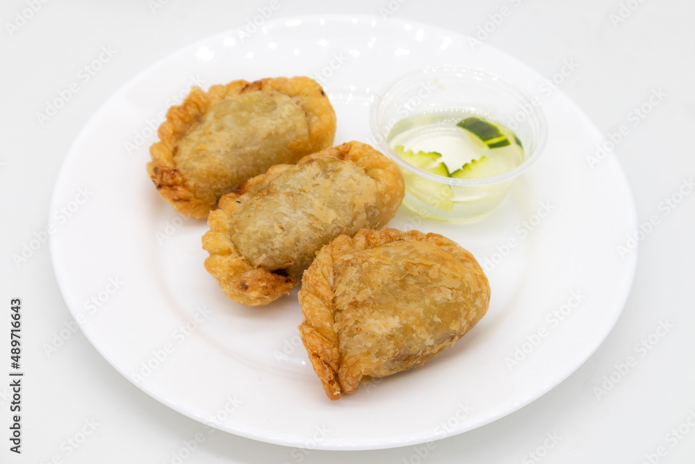Thai Curry Puffs on a White Plate with Sauce Thai Curry Puffs on a White Plate with Sauce