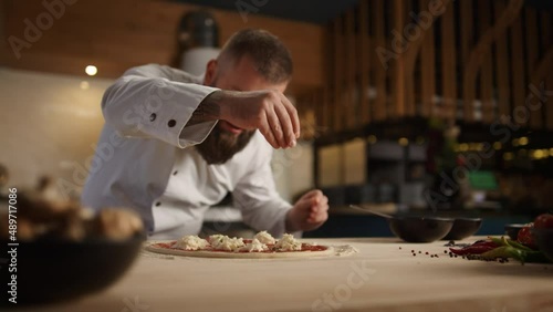 Professional chef making pizza dinner recipe in fine italian restaurant kitchen. photo