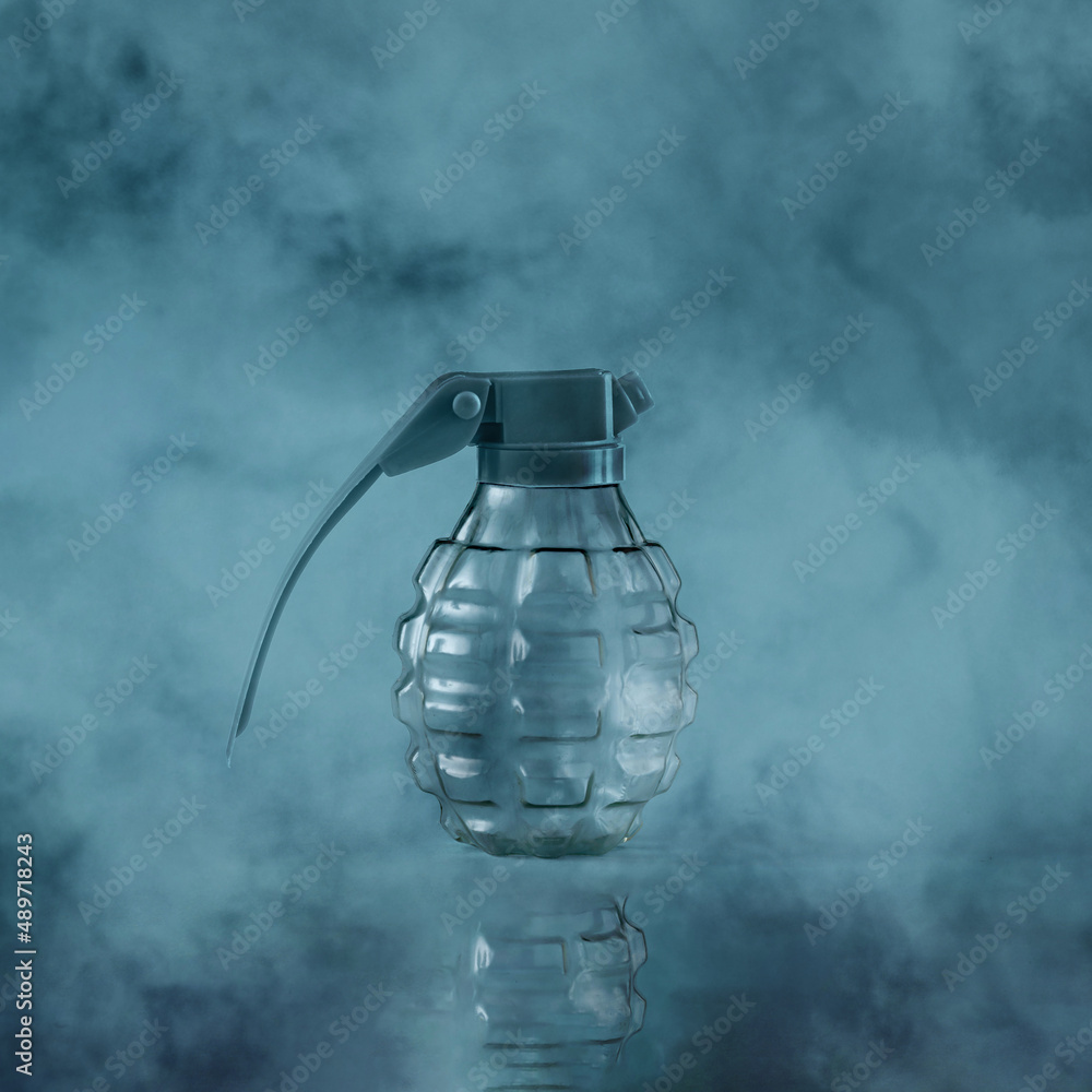 Close-up of a bomb in the fog on a gray-blue background. Minimal creative abstract concept of warning of dystopian future. Anti-war idea. Danger of war or fear of war.