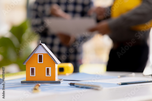 Close-up of a small house model, an architect engineer designs the house and its interior and draws a floor plan through a design program. Architect concept design house.