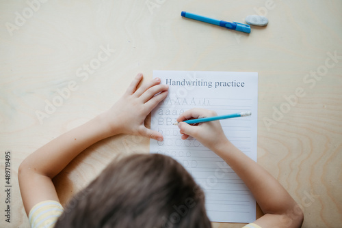 A schoolboy doing math lesson sitting at desk in the children room