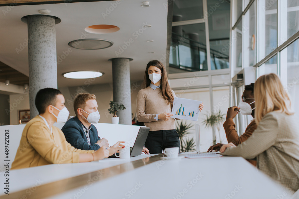 Fototapeta premium Group of multiethnic business people working together with facial protective masks and preparing new project on a meeting in office