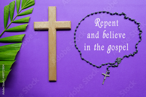 Cross and palm leaves with text on purple background. Holy week concept. photo