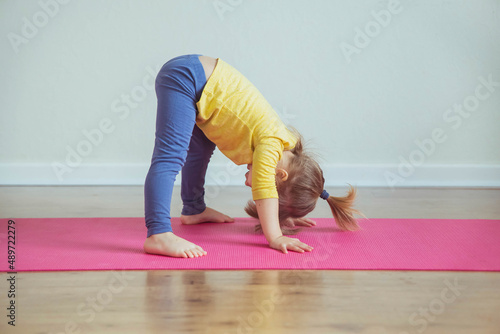 Charming baby doing yoga at home. Place for text