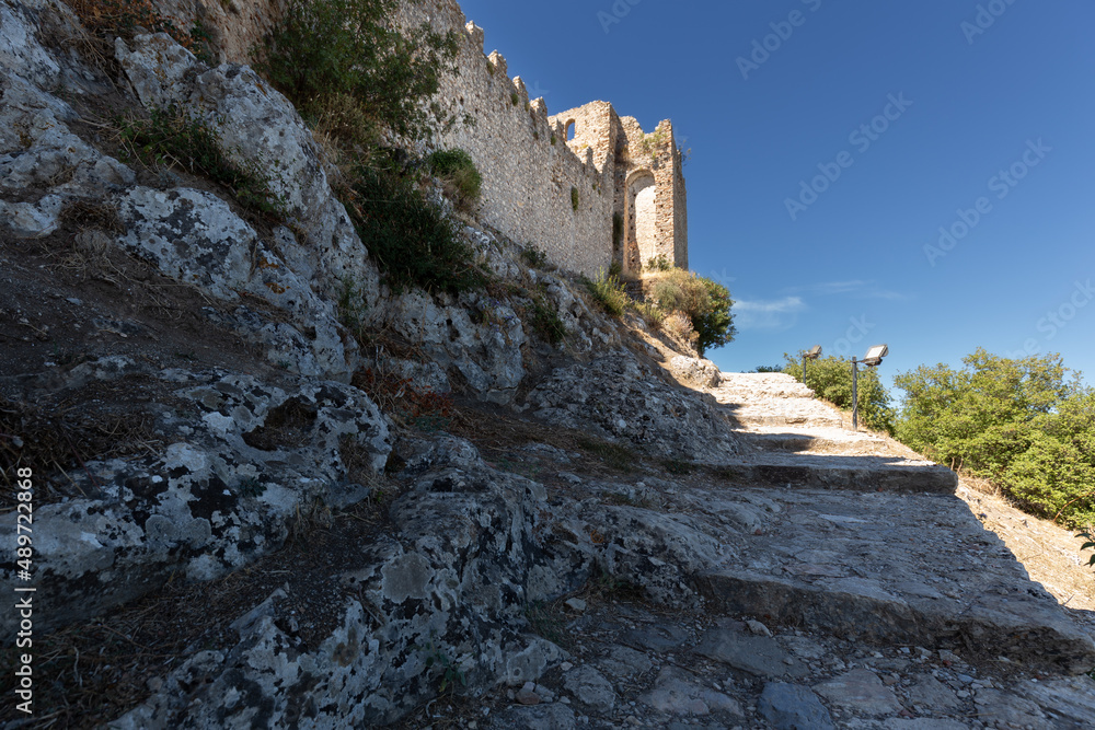 Ruins of stone wall and tower in ancient Fortress of Villehardouin on top of hill, Mystras, Greece