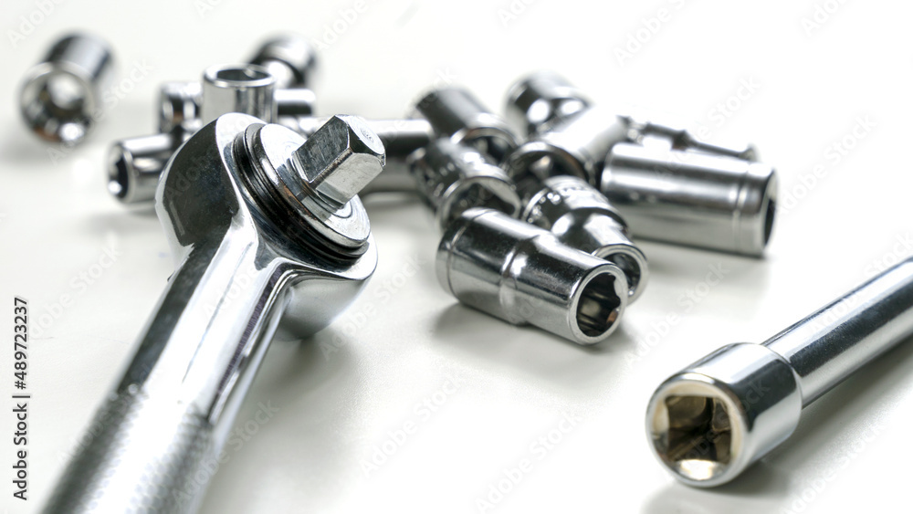 The tool is made of steel on the table in the workshop. The master selects the instrument with his hand. A beautiful chrome set of tools. The tool is made of steel on the table in the workshop. The master selects the instrument with his hand. A beautiful chrome set of tools.