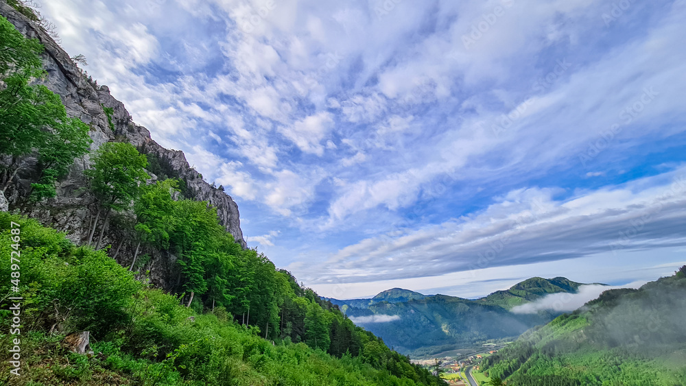 Scenic view from below mount Roethelstein near Mixnitz in Styria, Austria. Landscape of green alpine meadow, bushes and high grass in the valley of Grazer Bergland in Styria, Austria. Cloudscape