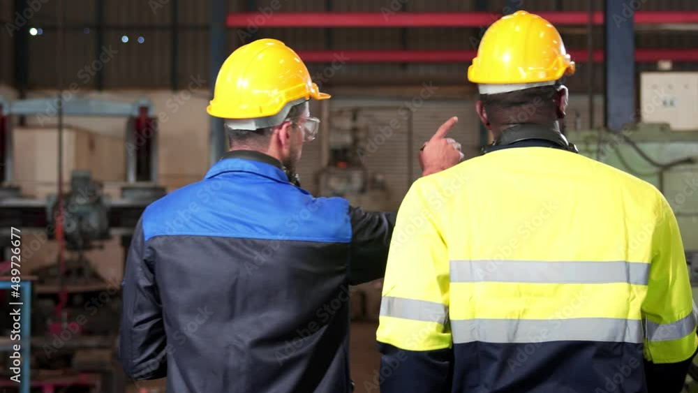 Back view of Diversity colleague industry team engineer. Professional technician, inspector, worker wearing safety uniform, helmet while checking, discuss maintenance machine line production factory. Back view of Diversity colleague industry team engineer. Professional technician, inspector, worker wearing safety uniform, helmet while checking, discuss maintenance machine line production factory.