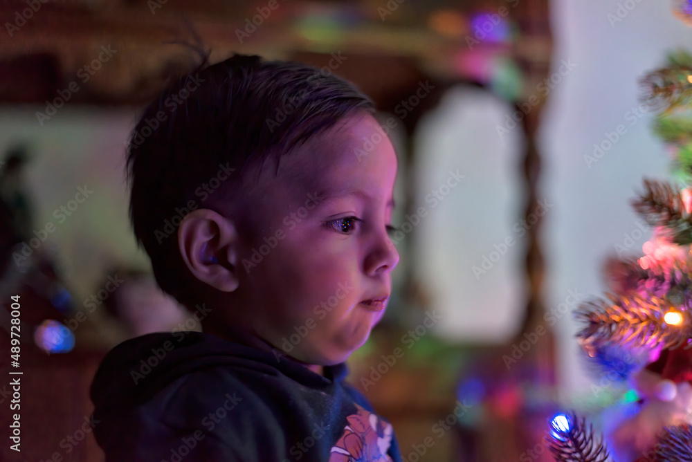 Young latin toddler watching the ornaments on the christmas tree Young latin toddler watching the ornaments on the christmas tree