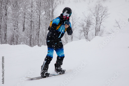 Snowboarder riding fast on snow freeride slope.