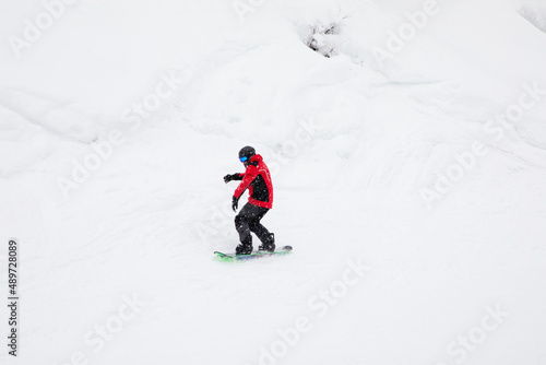 Snowboarder riding fast on snow freeride slope.