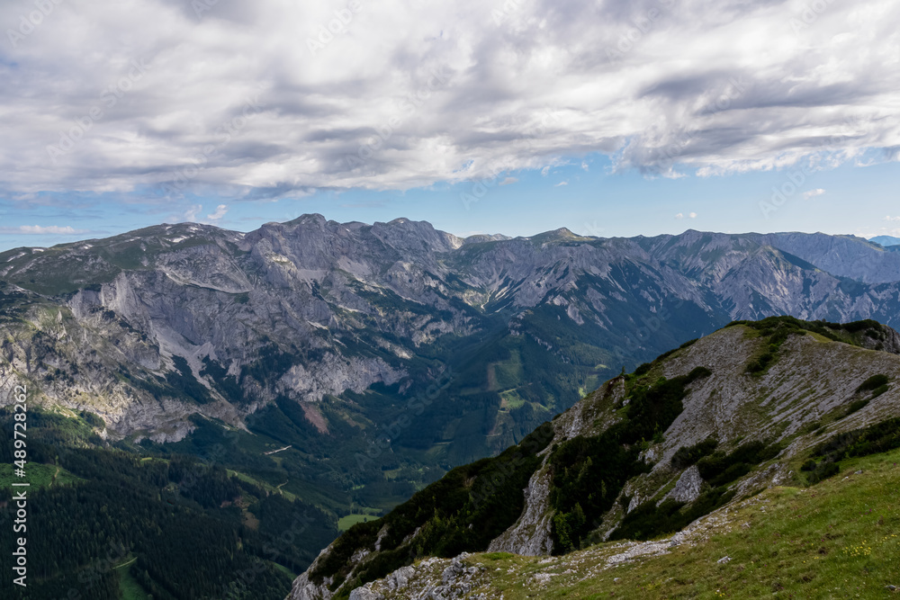 Panoramic view on the alpine mountain chains in Styria, Austria, Hochschwab region. Hills overgrown with small bushes, higher parts rocky and bare. Sunny summer day. Serenity. Hiking in Alps, Tragoess