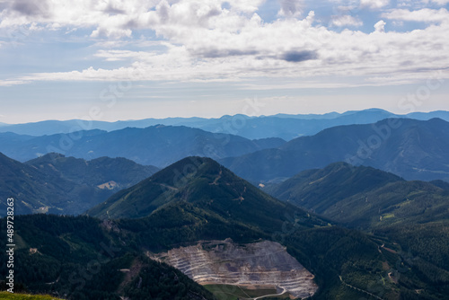 Panoramic view on ore mine and alpine valley in Hochschwab region in Styria, Austria. Lush green spring meadows. The slopes are overgrown with small bushes, higher parts baren. Clear and sunny day.