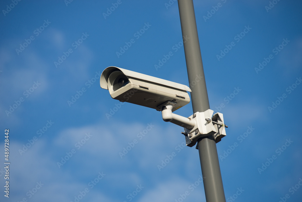 View of security camera on blue sky background View of security camera on blue sky background