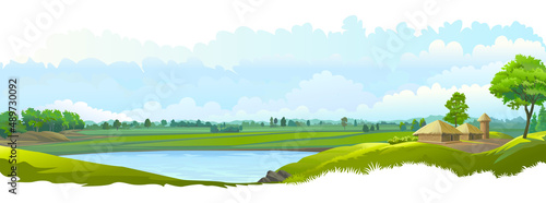 A beautiful lake is present in the middle of the rice fields. Farmhouses next to farmlands.