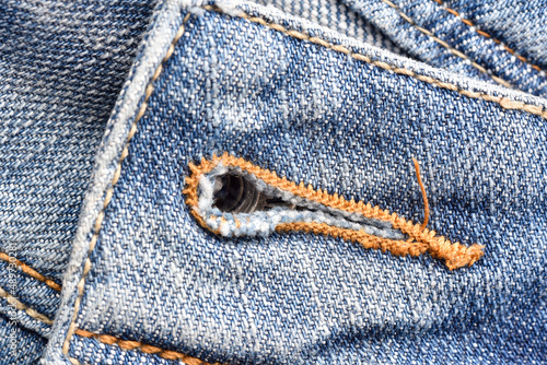 Macro of buttonhole jeans pants, Denim texture pattern, Close up of stitch threads, Fabric detail background.