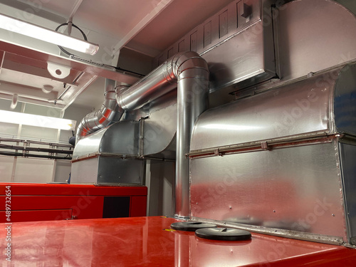 ship engine room with generators and hvac duct piping
