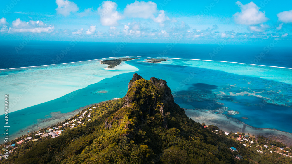 Mount Teurafaatiu summit view to blue Pacific ocean. View to atoll, blue laguna and sky. Maupiti island in French Polynesia.
