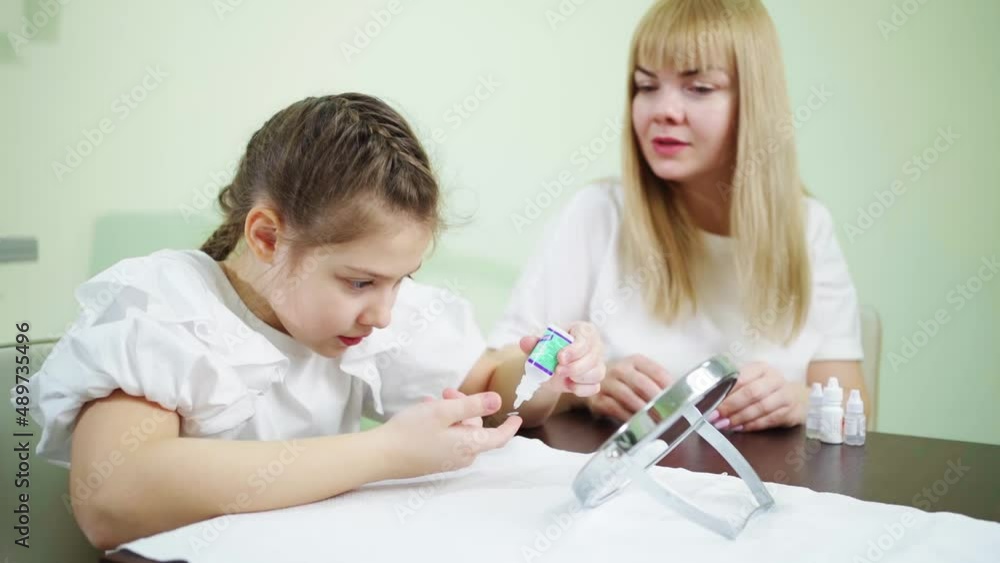 doctor teaches girl to wear contact lenses in clinic. orthokeratological lenses doctor teaches girl to wear contact lenses in clinic. orthokeratological lenses