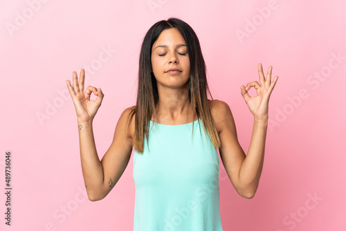 Caucasian girl isolated on pink background in zen pose