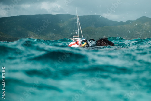 Taucher bei unruhiger See mit segelboot im Hintergrund in deer Karibik