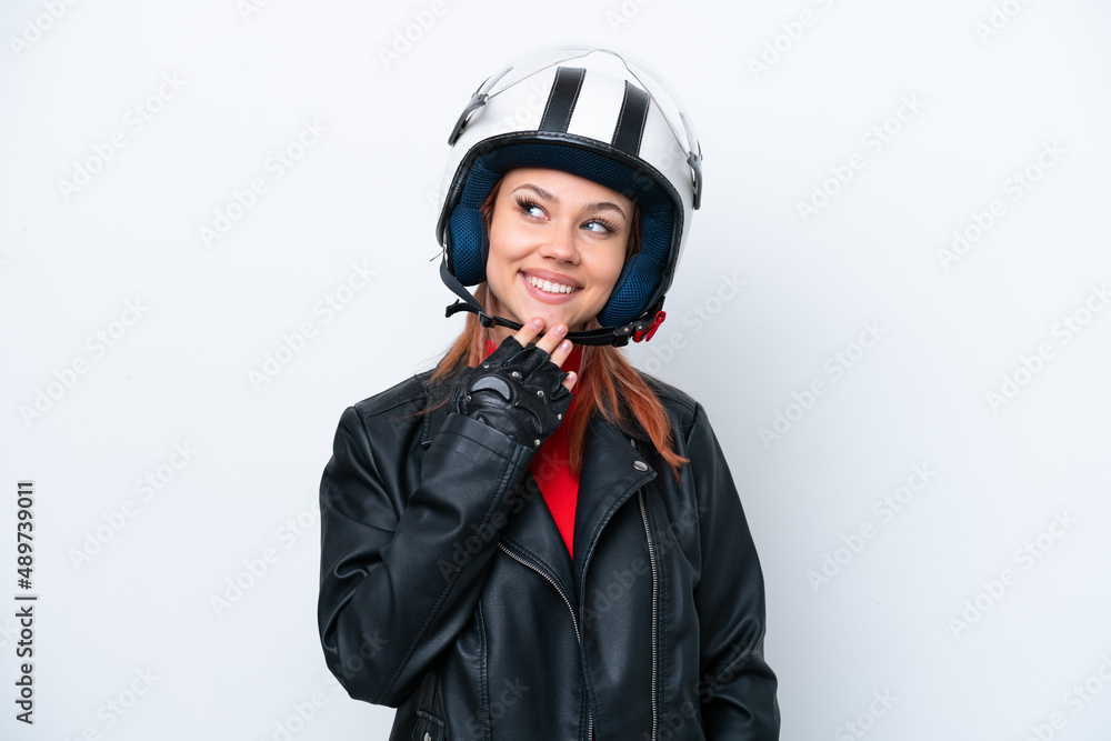 Young Russian girl with a motorcycle helmet isolated on white background looking up while smiling Young Russian girl with a motorcycle helmet isolated on white background looking up while smiling