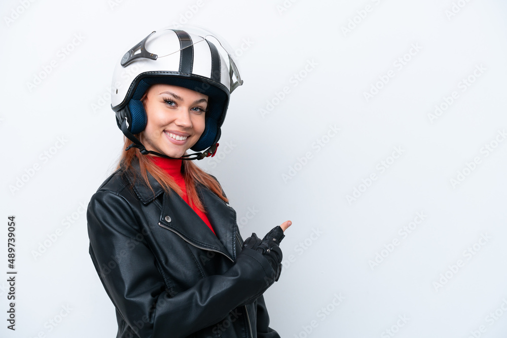 Young Russian girl with a motorcycle helmet isolated on white background pointing back Young Russian girl with a motorcycle helmet isolated on white background pointing back
