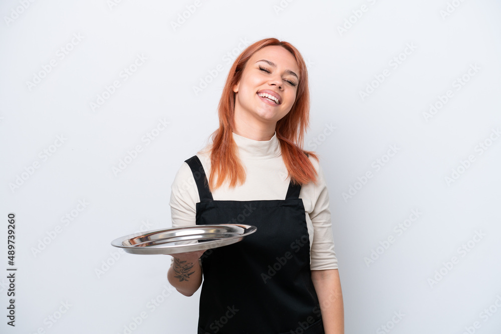 Young Russian waiter with tray isolated on white background laughing Young Russian waiter with tray isolated on white background laughing