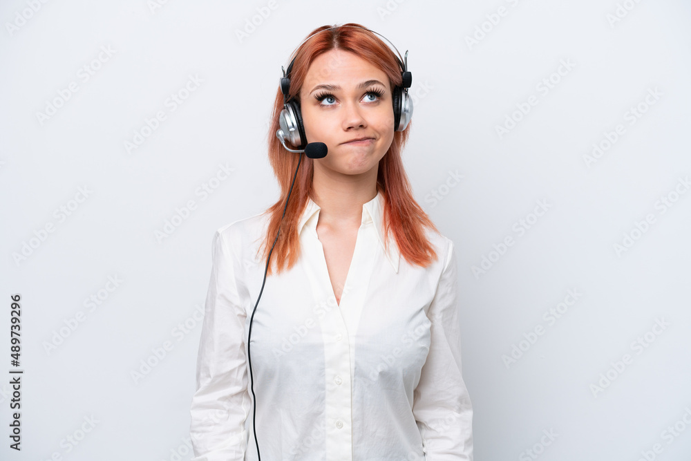 Telemarketer Russian girl working with a headset isolated on white background and looking up Telemarketer Russian girl working with a headset isolated on white background and looking up