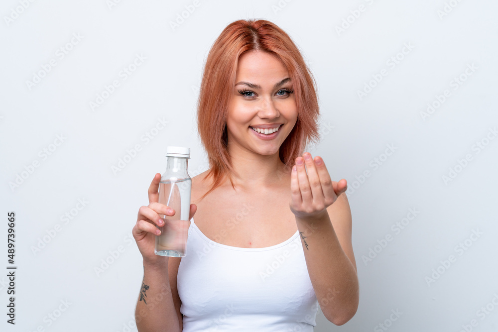 Young Russian girl with a bottle of water isolated on white background inviting to come with hand. Happy that you came Young Russian girl with a bottle of water isolated on white background inviting to come with hand. Happy that you came