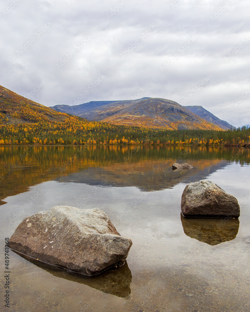 Lake with turquoise water in the mountains in autumn on a cloudy day. view from above
