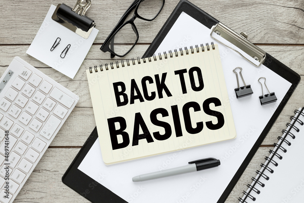 Back to Basics, notepad with text on a wooden table and a folder with a clip. keyboard . working table Back to Basics, notepad with text on a wooden table and a folder with a clip. keyboard . working table