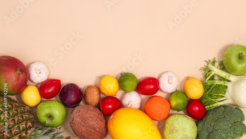Flat lay creative copy space background with fresh fruits and vegetables on pastel beige theme. Organic food concept