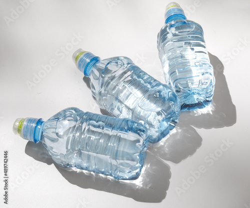 plastic bottles with clear pure water isolated on light surface