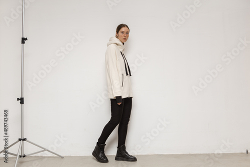 Stylish and beautiful girl in the studio posing against a concrete wall
