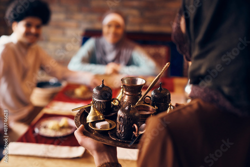 Close-up of Middle Eastern woman serving traditional Turkish coffee at home
